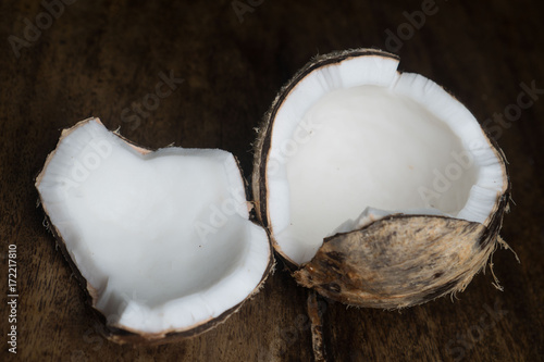 Closeup of ripe half coconut isolated on wooden table background
