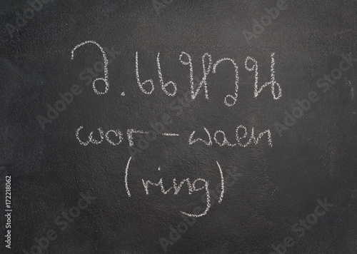 Thai letter written with white chalk on blackboard photo