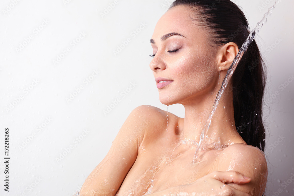 Naklejka premium Young beautyful woman under shower in bathroom.