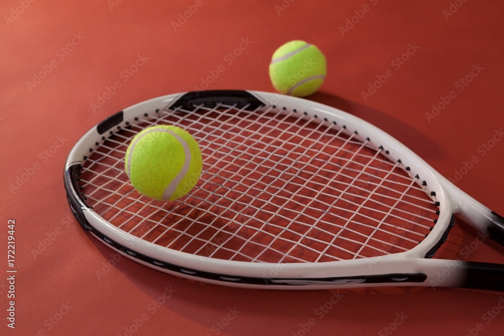 High angle view of tennis racket and fluorescent yellow balls