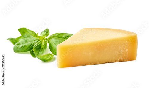 Parmesan cheese with basil leaves on white background. Italian cheese slices.