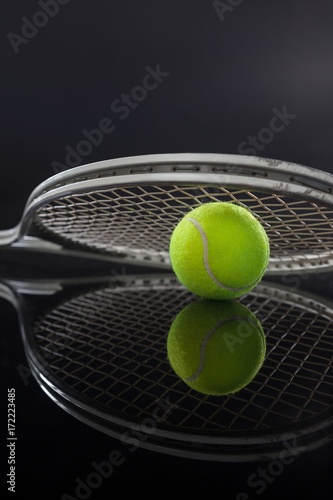 Symmetrical view of tennis racket on ball with reflection