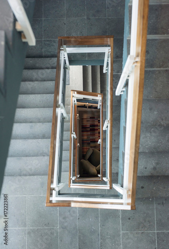 Top view of industrial stairwell with armchair on the ground floor.