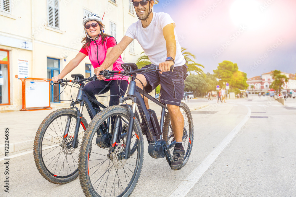Obraz premium Pärchen mit dem E-Bike im Urlaub im Süden