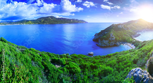 Beautiful summertime panoramic seascape. View of the cliff into the crystal clear azure sea bay and distant islands. Unique secluded beach. Agios Stefanos cape. Afionas. Corfu. Greece.