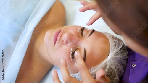 cosmetologist applying skin cream under eyes. Beauty eye contour wrinkle cream or anti-aging skin care cream. young woman's face with points of cream under the eyes