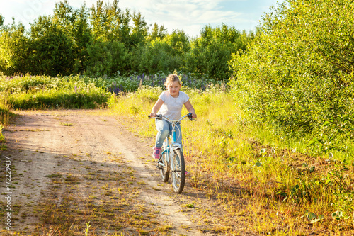 Smiling little girl on a bicycle