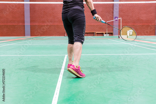 badminton woman player wearing sportswear standing holding racket and shutter-cock in badminton court © ttanothai