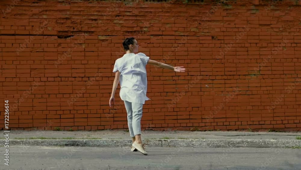 Ballet dancer. The young beautiful dark woman rotating around herself in the dance in the street. Slow motion. HD Ballet dancer. The young beautiful dark woman rotating around herself in the dance in the street. Slow motion. HD