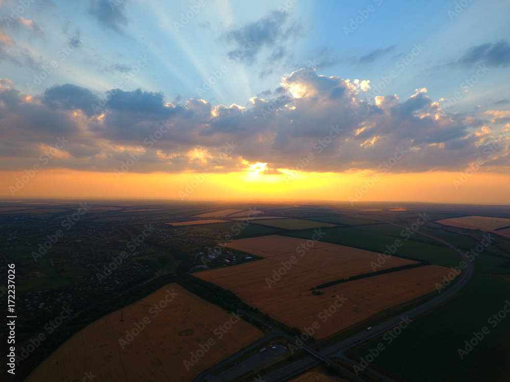 Aerial view of beautiful village, houses, roads. Sky, clouds, sunset.