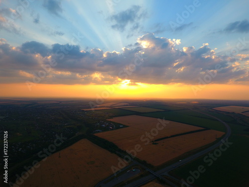 Aerial view of beautiful village, houses, roads. Sky, clouds, sunset.
