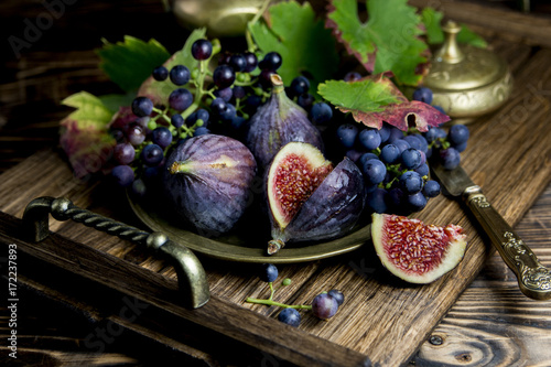  спелый инжир и виноград на деревянном подносе