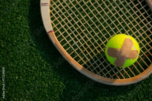 Overhead view of tennis ball with bandage on racket