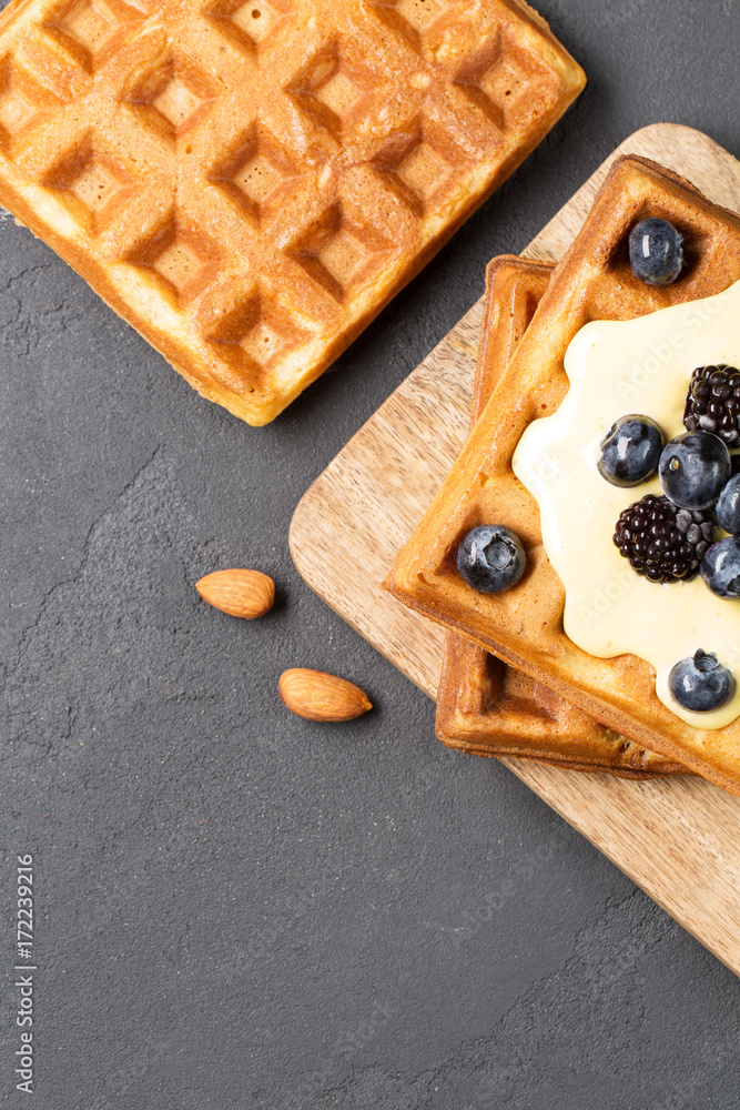 Crispy wafers with cream and berries, vertical, top view, black background, close-up, soft focus Crispy wafers with cream and berries, vertical, top view, black background, close-up, soft focus