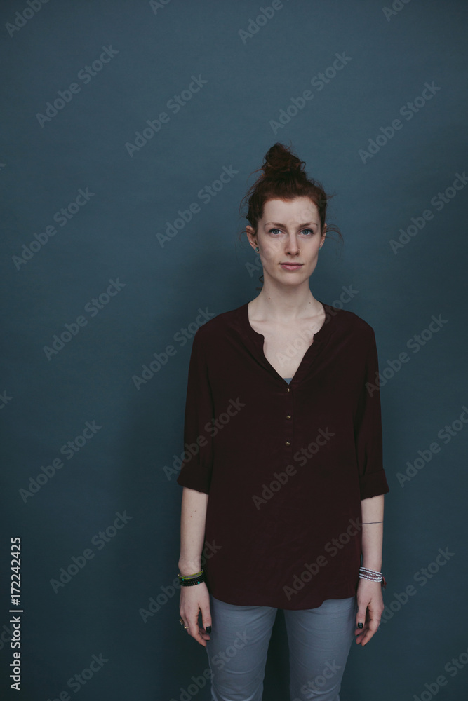 Serious portrait of young red head on solid background Serious portrait of young red head on solid background