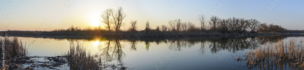 sunset on the lake, the dark silhouette of the trees and reeds reflected on the water, panorama, landscape sunset on the lake, the dark silhouette of the trees and reeds reflected on the water, panorama, landscape