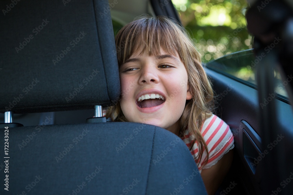 Foto de Teenage girl sitting in the back seat of car do Stock Adobe Stock