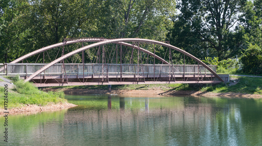 The arched railing makes for an eye pleasing view of this bridge and waterway with glimpses of the bridge reflecting in the water. The arched railing makes for an eye pleasing view of this bridge and waterway with glimpses of the bridge reflecting in the water.