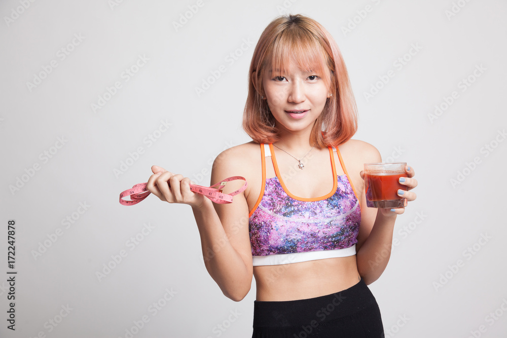 Healthy Asian girl diet with tomato juice and measuring tape on diet. Healthy Asian girl diet with tomato juice and measuring tape on diet.