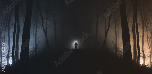 Man in surreal haunted forest on Halloween night photo