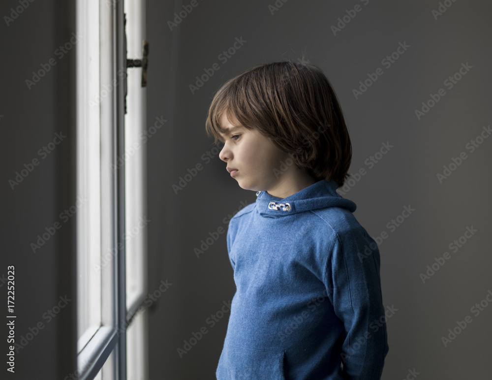 Portrait of a boy looking outside of the window Portrait of a boy looking outside of the window