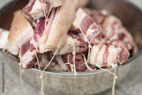 Close-up of salted and baked pork with ropes in metal bowl