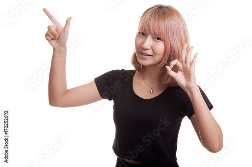 Young Asian woman point and show OK.