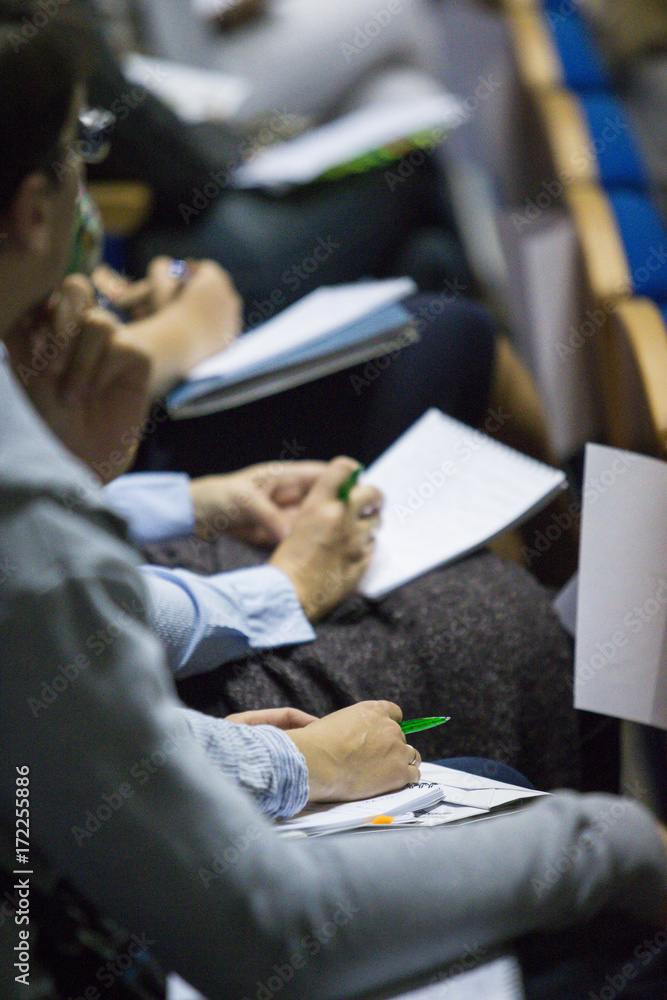 © danmorgan12 - Group of People Making Notes at Conference. Sitting in One Line. Blurred Image.