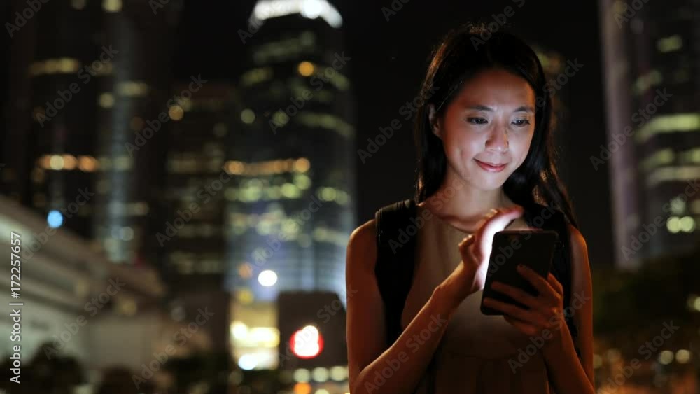 Woman using mobile phone at night in the city Woman using mobile phone at night in the city