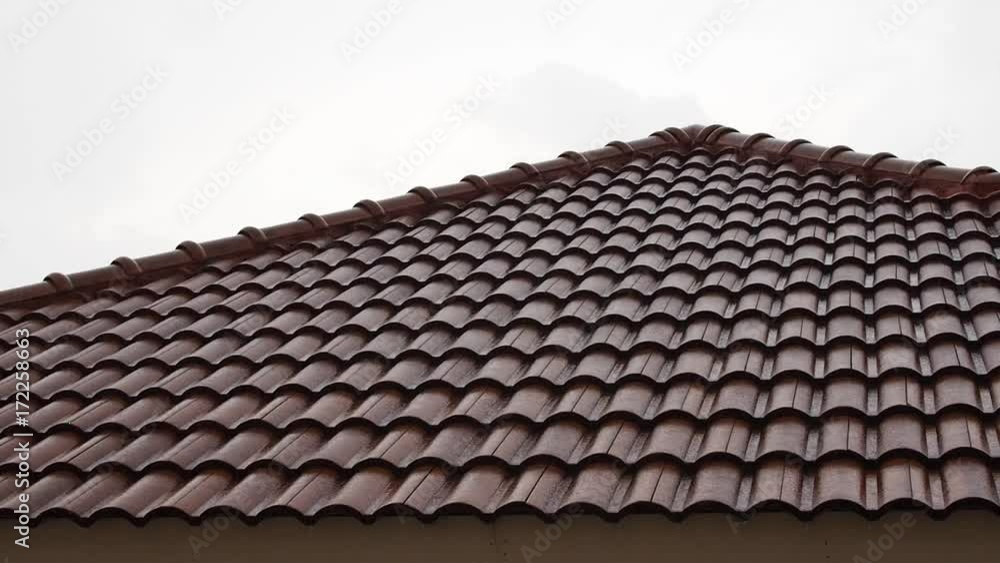Rain water fall splashing on dark old red brown corrugated cement house triangle roof Rain water fall splashing on dark old red brown corrugated cement house triangle roof