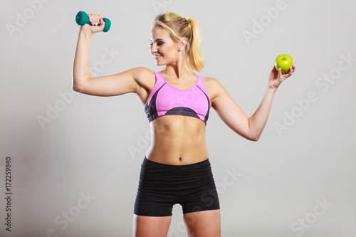 Diet fit body. Girl holds dumbbells and apple fruit