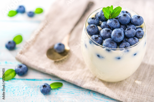 Bowl of blueberries  yogurt on wooden background , top view