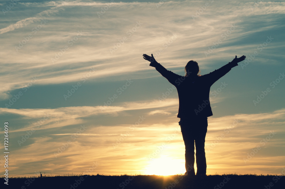 Fototapeta premium a woman with her arms raised in joy.