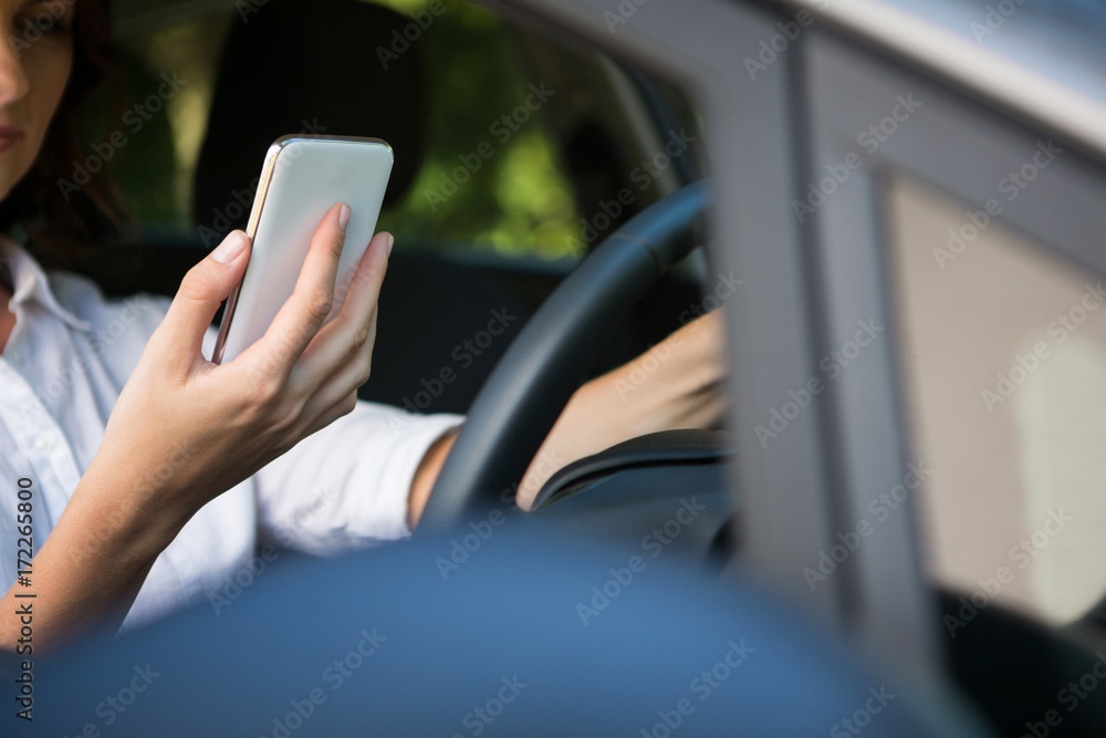 Woman using mobile phone while driving a car