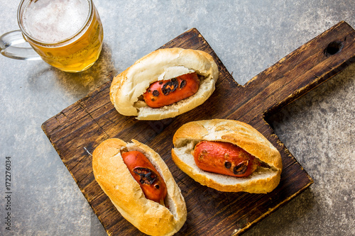 Choripan. Latin American Argentine and chilean food. Grilled chorizo sausages hot dogs served with beer, top view, stone background photo