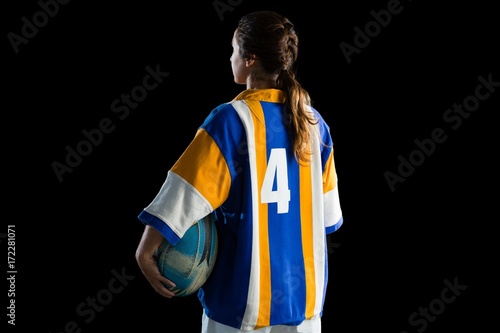Rear view of female athlete holding rugby ball