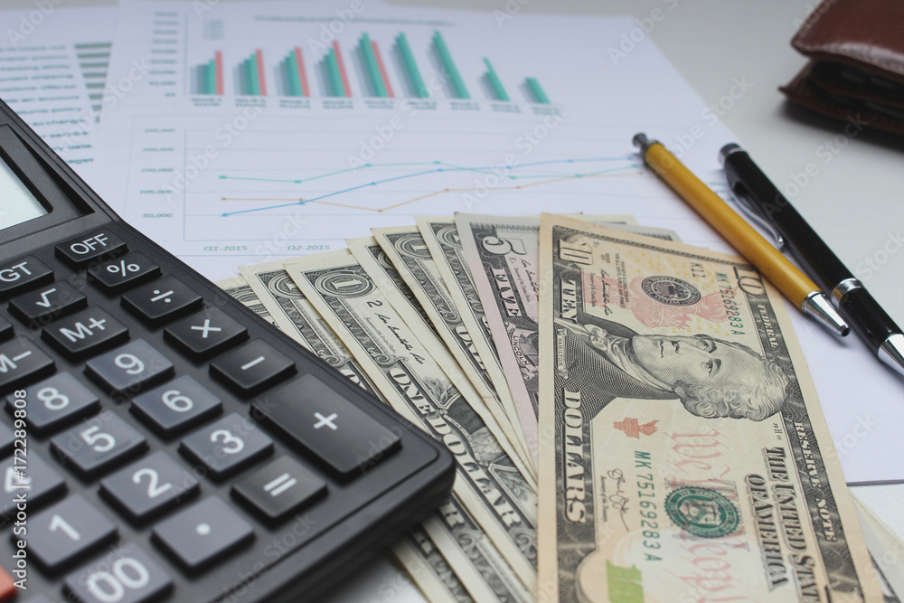 Calculator and Dollar money on the office desk investment and property for concept Calculator and Dollar money on the office desk investment and property for concept