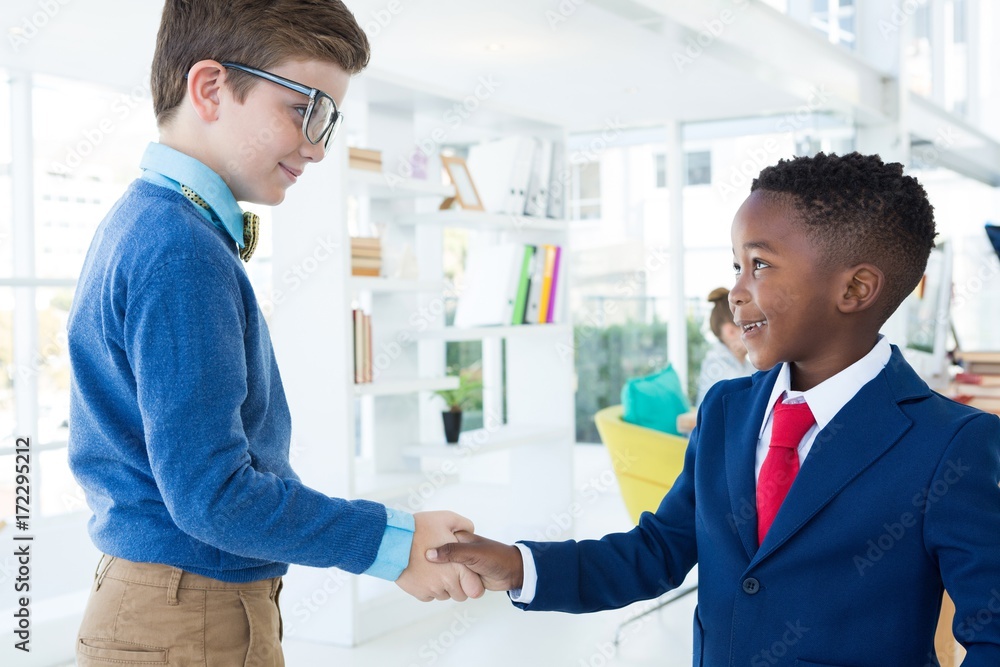 Kids as business executives shaking hands Kids as business executives shaking hands