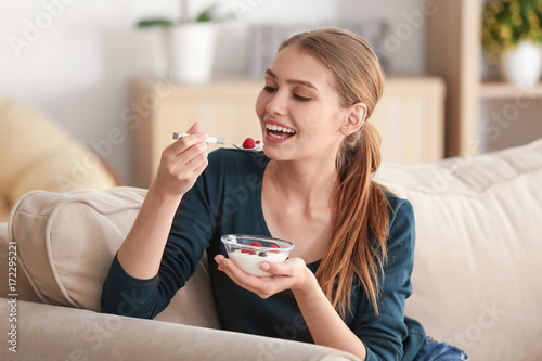 Young woman eating yogurt o...