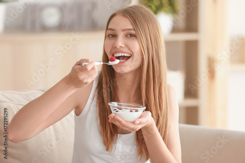 Young woman eating yogurt o...