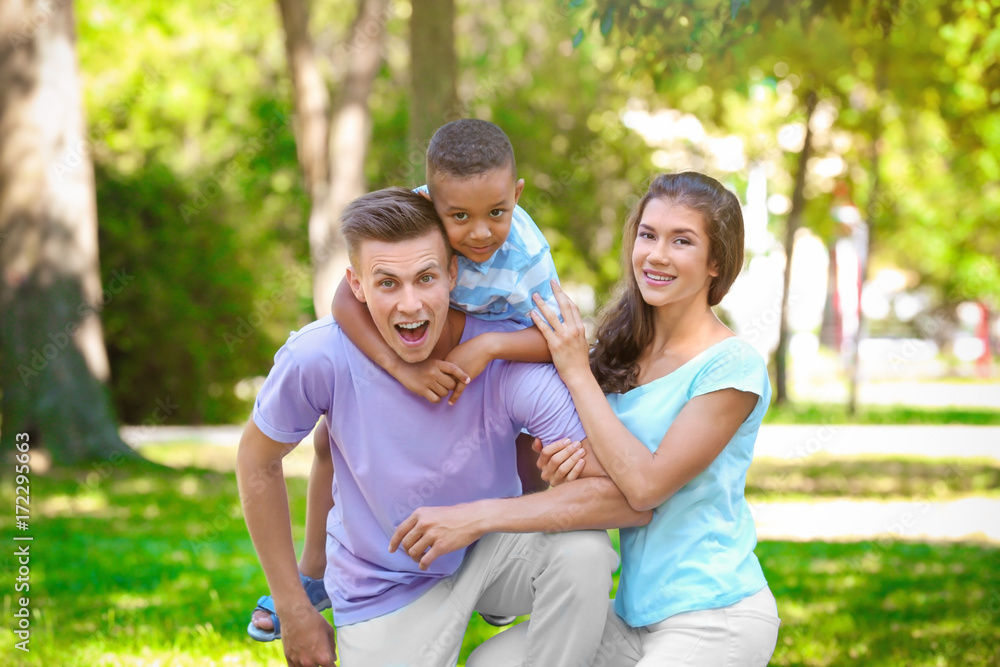 Young family with adopted African American boy outdoors Young family with adopted African American boy outdoors