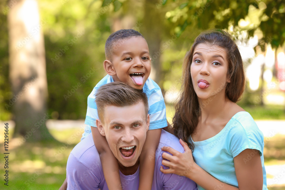 Young family with adopted African American boy having fun outdoors Young family with adopted African American boy having fun outdoors