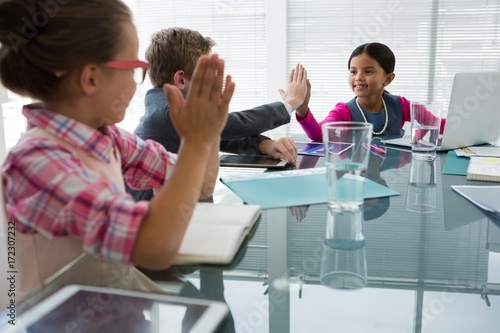 Kids as business executives interacting while meeting photo