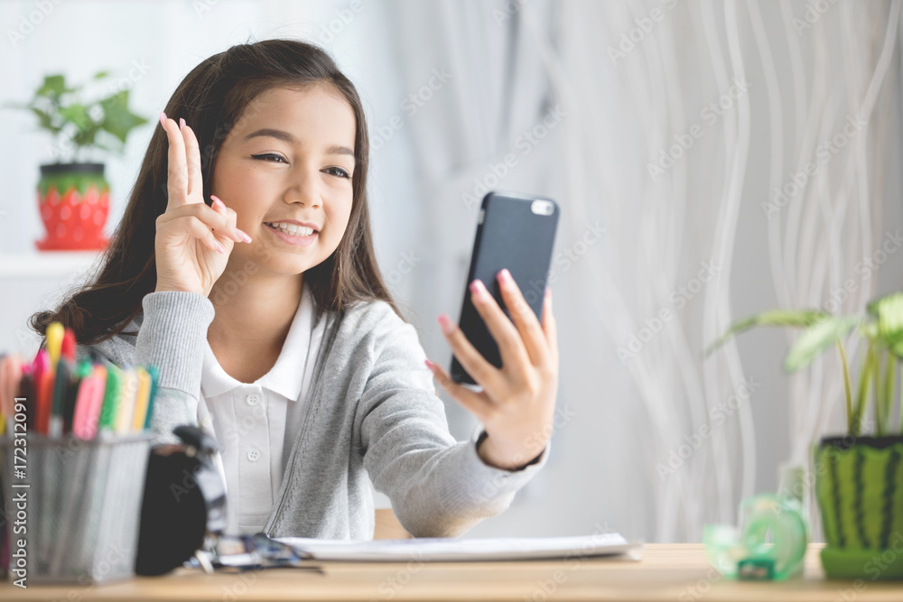 Portrait of a smiling girl pointing finger and take a photo by mobile phone Portrait of a smiling girl pointing finger and take a photo by mobile phone