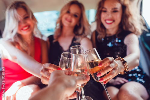 Canvas Print Pretty women having party in a limousine car and drinking champagne