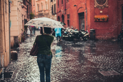 Woman under umbrella in heavy rain