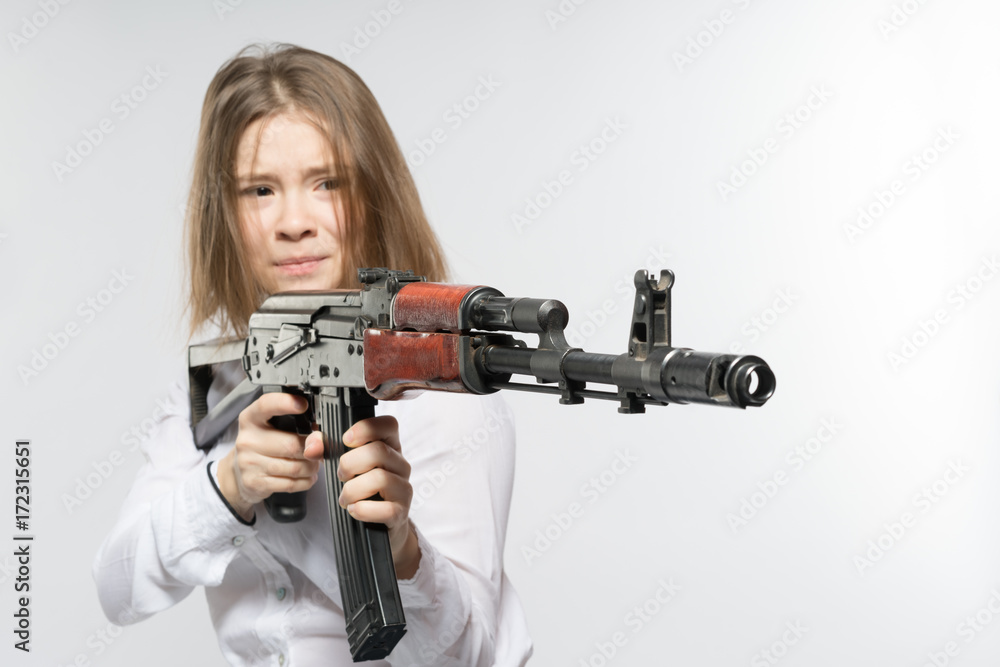 Girl with a frightened look with a Kalashnikov in his hand. Isolated Girl with a frightened look with a Kalashnikov in his hand. Isolated