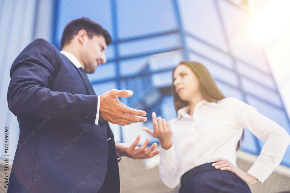 The business woman and man arguing near the modern building