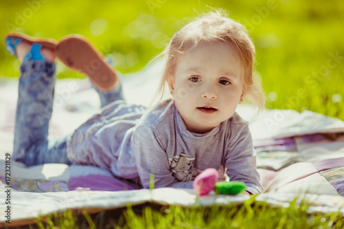 Child plays with little toys on the lawn