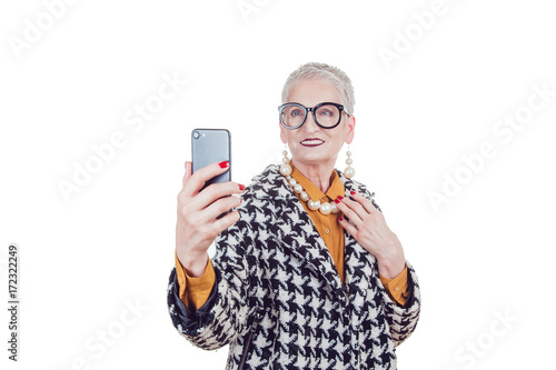 Stylish old woman in glassesmakes selfie isoladed on white. photo